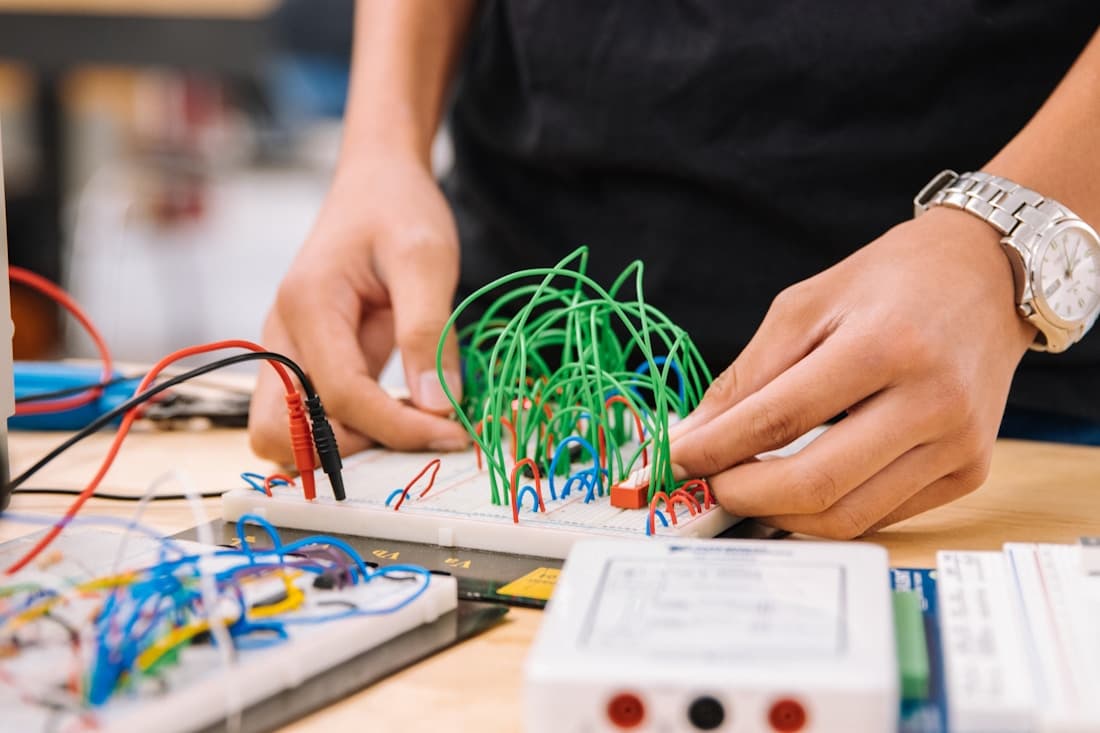 Hands assembling an electronic circuit during a practical learning activity